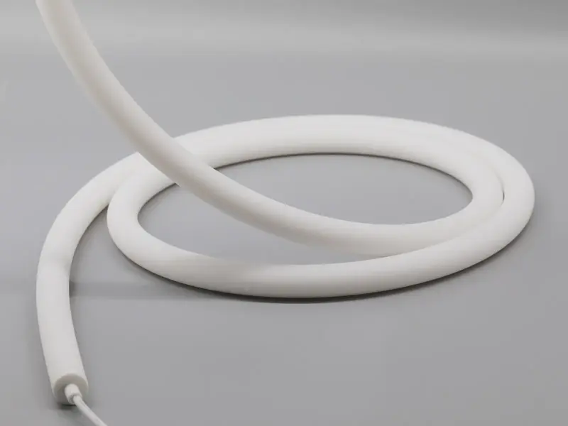 Round 360 degree LED neon flex tube coiled on a white surface