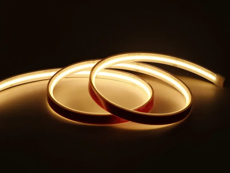 High-temperature silicone LED strip coiled and glowing warm white