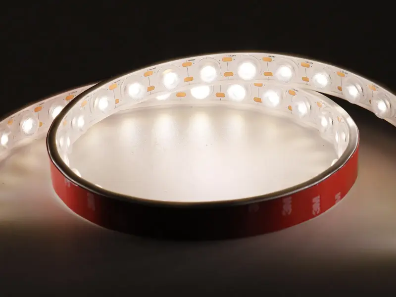 PU-potted LED strip coiled and lit in warm white, round lens over each LED, 3M adhesive backing on the reverse