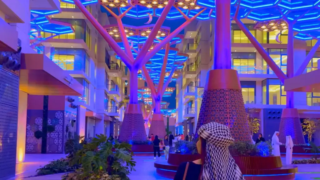 Crystal Corridor promenade in Doha at night, with blue LED neon flex lighting the hexagon canopy above visitors